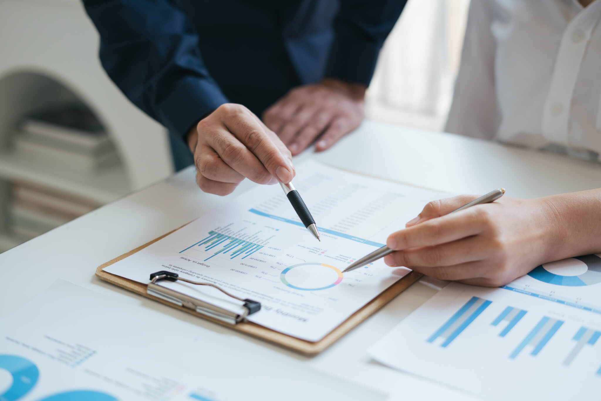 A professional meeting room with businesspeople evaluating manufacturing options